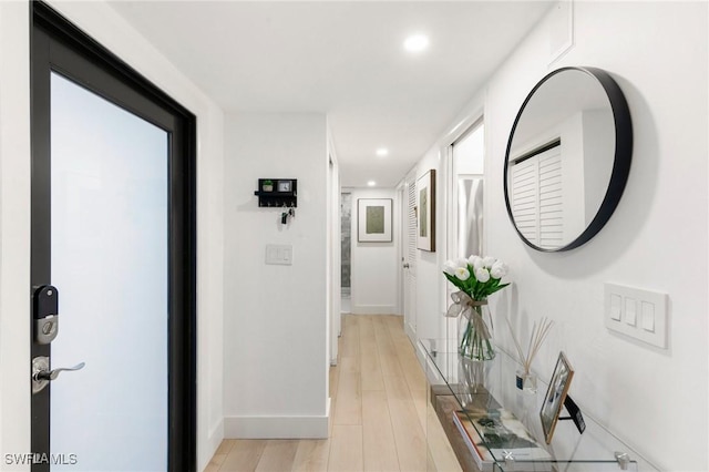 hallway featuring recessed lighting, light wood-style flooring, and baseboards