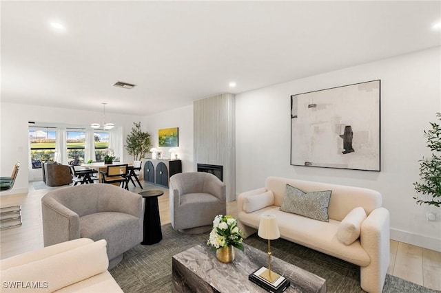 living room featuring recessed lighting, a large fireplace, wood finished floors, visible vents, and baseboards