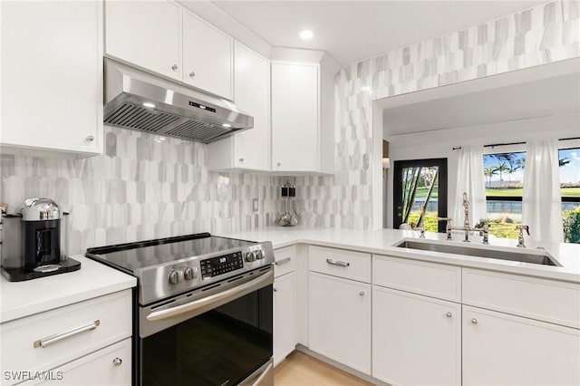 kitchen featuring under cabinet range hood, a sink, white cabinetry, electric stove, and light countertops