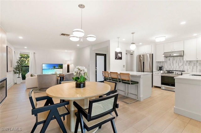 dining room with light wood-style floors, visible vents, and recessed lighting