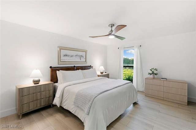 bedroom featuring a ceiling fan, baseboards, light wood finished floors, and radiator heating unit