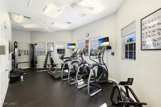 gym with baseboards, visible vents, and a ceiling fan