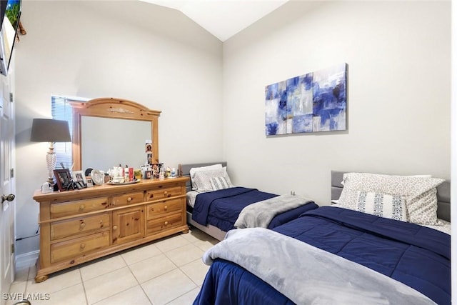 bedroom with light tile patterned floors and vaulted ceiling