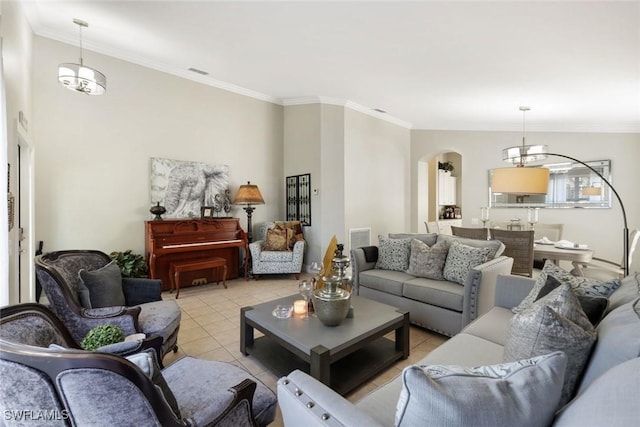 living area featuring arched walkways, light tile patterned floors, visible vents, and crown molding