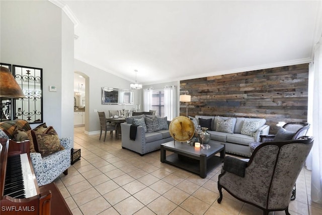 living area with light tile patterned floors, arched walkways, vaulted ceiling, and ornamental molding