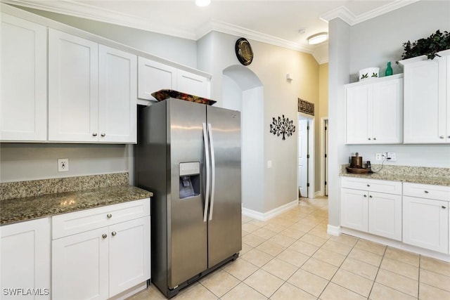 kitchen with crown molding, stainless steel refrigerator with ice dispenser, stone countertops, white cabinets, and light tile patterned flooring