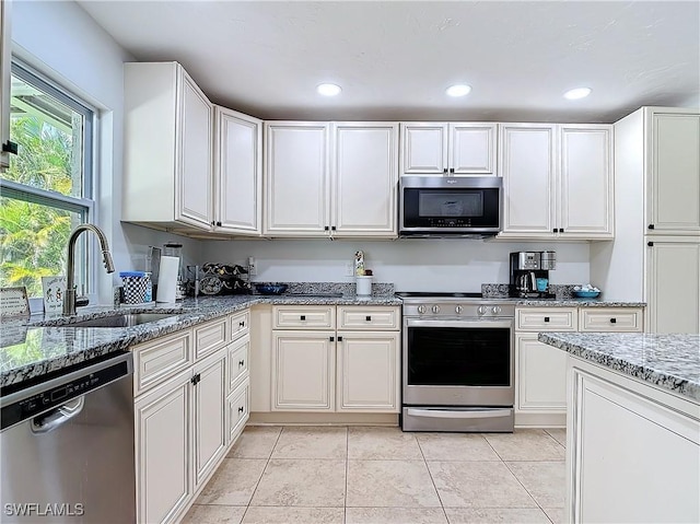 4364 Beechwood Lake Dr, Naples, FL 34112 - kitchen with appliances with stainless steel finishes, white cabinets, light tile patterned flooring, a sink, and light stone countertops