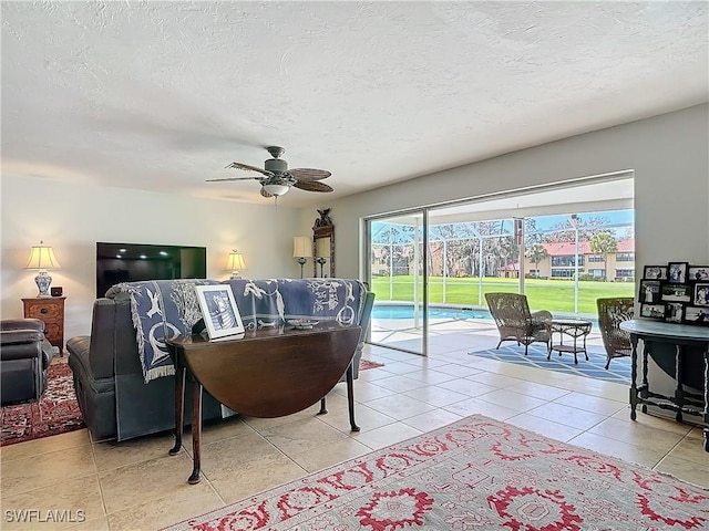 4364 Beechwood Lake Dr, Naples, FL 34112 - living room featuring a ceiling fan, a textured ceiling, and light tile patterned floors