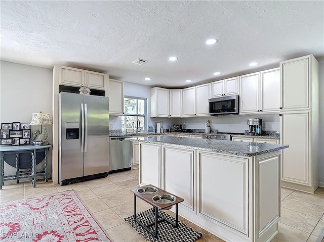 4364 Beechwood Lake Dr, Naples, FL 34112 - kitchen featuring stainless steel appliances, a sink, a kitchen island, visible vents, and dark stone countertops