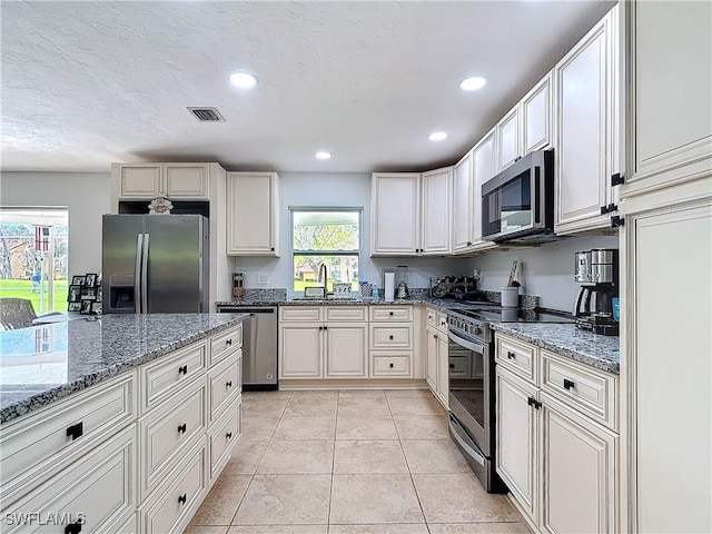 4364 Beechwood Lake Dr, Naples, FL 34112 - kitchen featuring light tile patterned floors, recessed lighting, stainless steel appliances, a sink, and light stone countertops