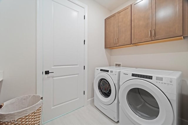 laundry room with washing machine and dryer and cabinet space