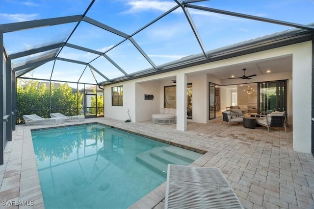 pool featuring outdoor lounge area, glass enclosure, a patio area, and ceiling fan