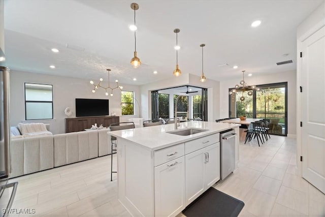 kitchen featuring open floor plan, light countertops, recessed lighting, a notable chandelier, and white cabinets