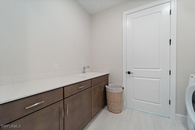 bathroom featuring vanity, washer / dryer, and tile patterned flooring