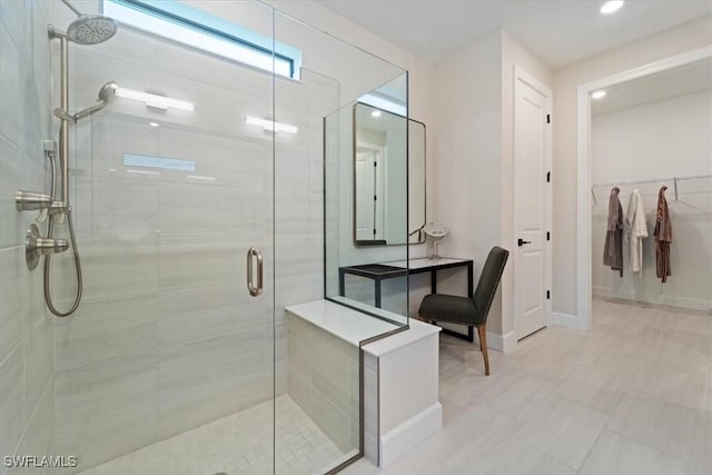 full bath featuring a closet, a stall shower, and baseboards