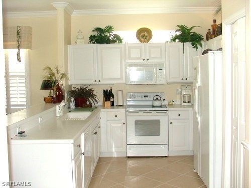 kitchen with white appliances, light tile patterned floors, ornamental molding, and light countertops