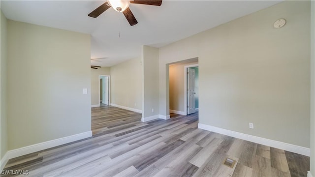 unfurnished room featuring a ceiling fan, visible vents, baseboards, and wood finished floors