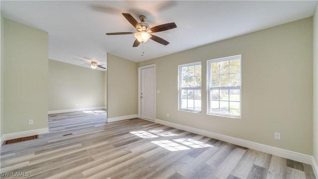 spare room featuring light wood-style floors, baseboards, and a ceiling fan