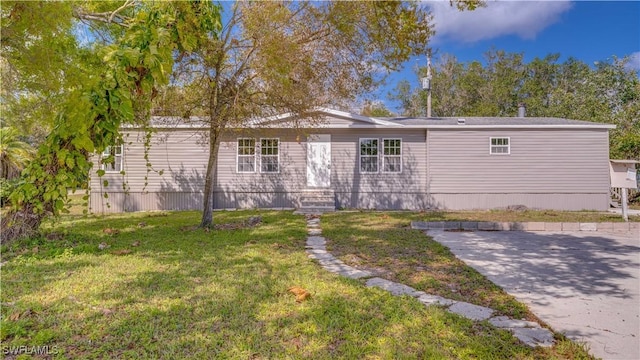 manufactured / mobile home with entry steps and a front lawn