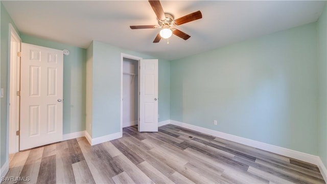 unfurnished bedroom with a ceiling fan, a closet, baseboards, and wood finished floors