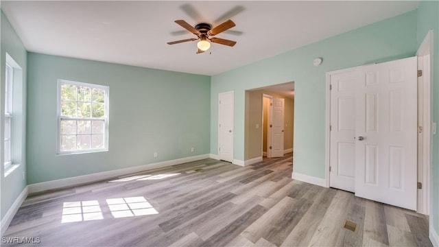 unfurnished bedroom with a ceiling fan, baseboards, and wood finished floors