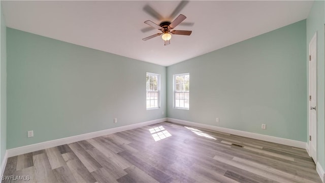 unfurnished room featuring lofted ceiling, wood finished floors, and baseboards