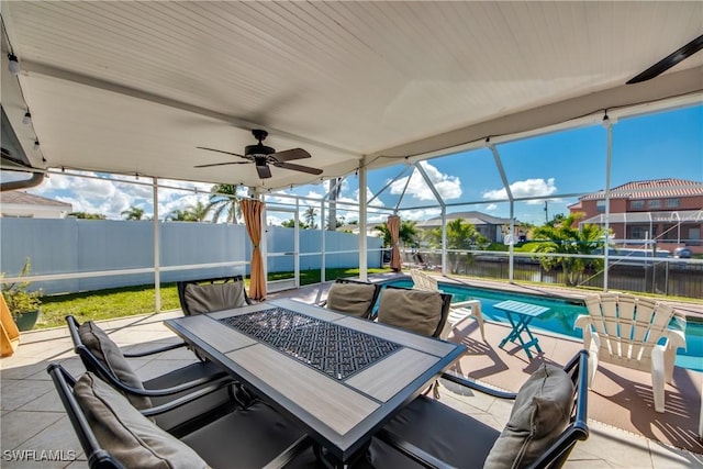 view of patio / terrace featuring glass enclosure, a fenced backyard, a ceiling fan, a fenced in pool, and outdoor dining space