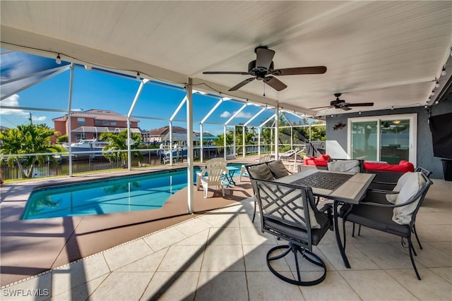 view of swimming pool with ceiling fan, glass enclosure, a patio area, and a fenced in pool