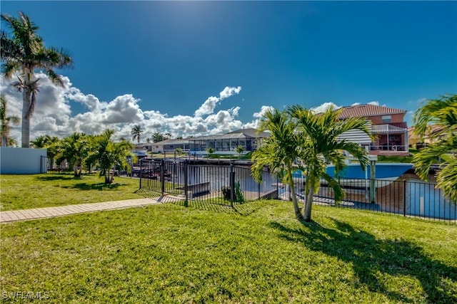 view of property's community with fence and a yard