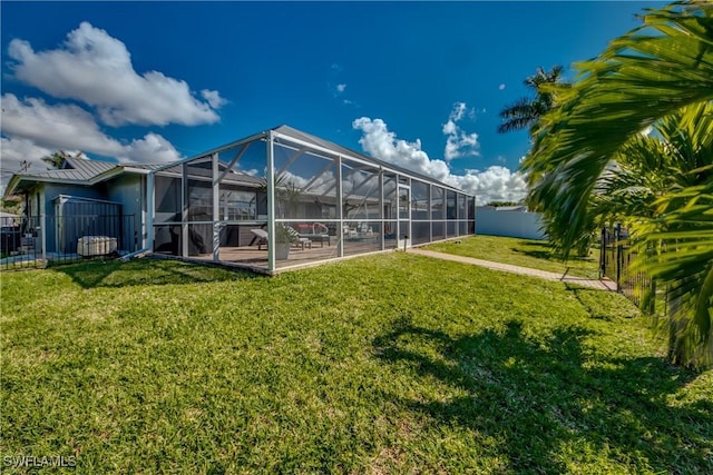 rear view of property with a lanai, a fenced backyard, a patio, and a yard