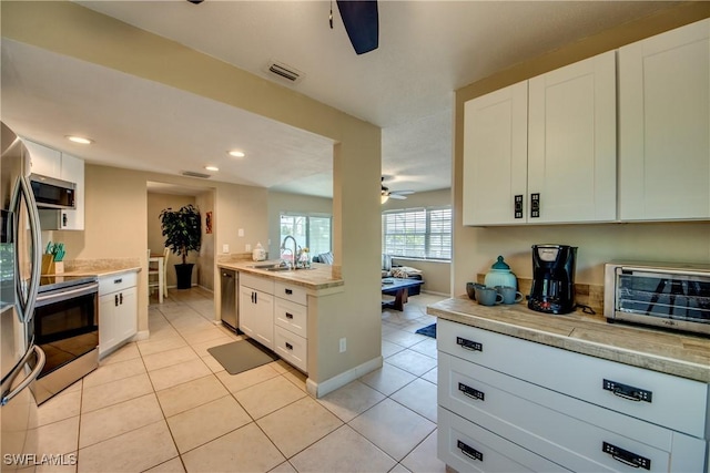 kitchen featuring light tile patterned floors, visible vents, appliances with stainless steel finishes, a sink, and ceiling fan