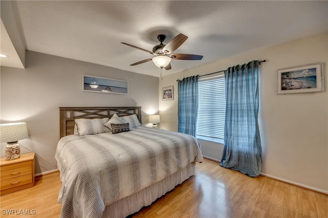 bedroom featuring light wood-style floors, ceiling fan, and baseboards