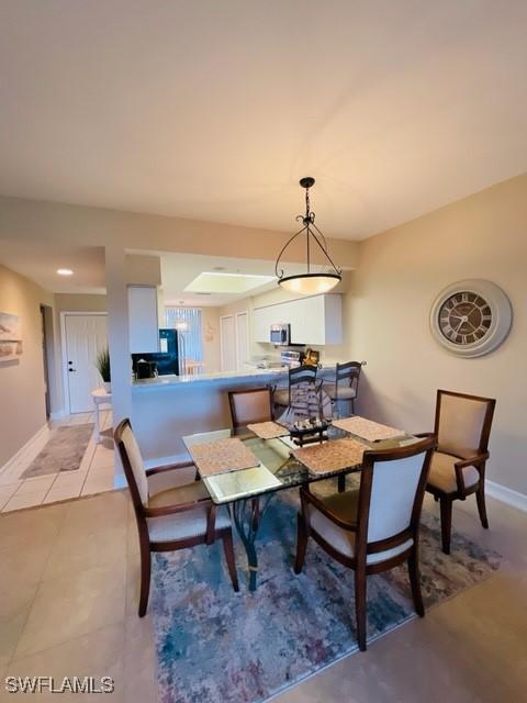 dining area with baseboards and light tile patterned floors