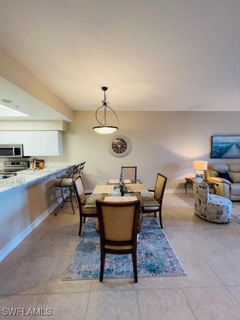 dining space featuring baseboards and light tile patterned floors