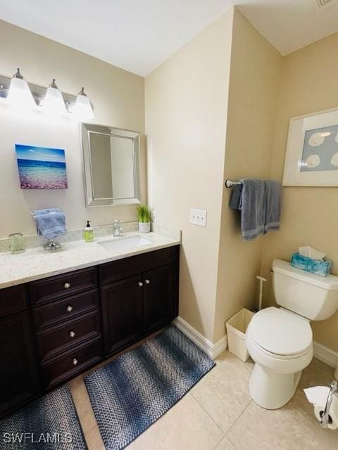 bathroom featuring toilet, tile patterned flooring, baseboards, and vanity