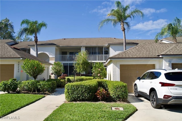 view of front facade with an attached garage, roof with shingles, concrete driveway, and stucco siding