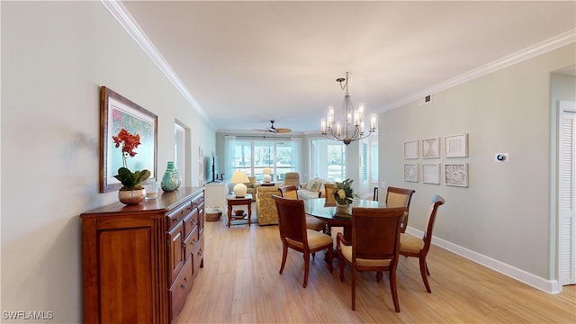 dining area with visible vents, baseboards, crown molding, light wood-style floors, and a chandelier