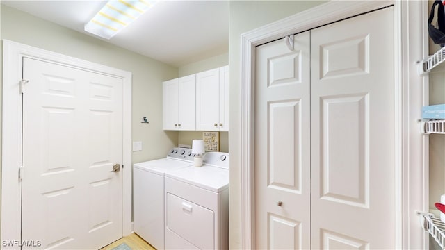 washroom featuring cabinet space and separate washer and dryer