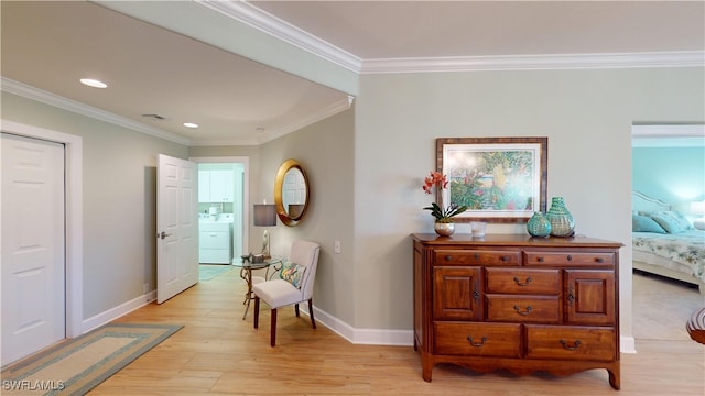 hall with baseboards, washer / clothes dryer, light wood-type flooring, and crown molding