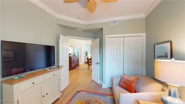 living area with a ceiling fan, visible vents, light wood-style floors, and crown molding