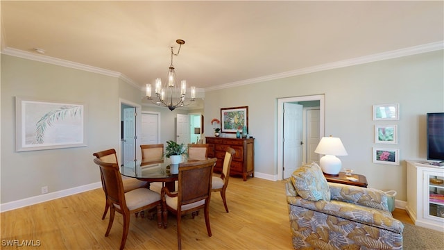 dining room featuring light wood-style floors, ornamental molding, baseboards, and an inviting chandelier