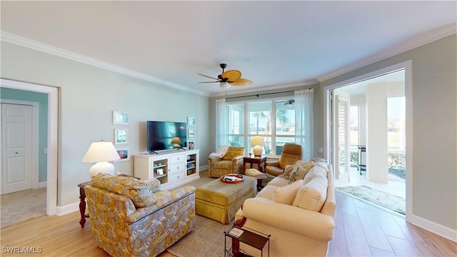 living area with ornamental molding, light wood-type flooring, baseboards, and a ceiling fan