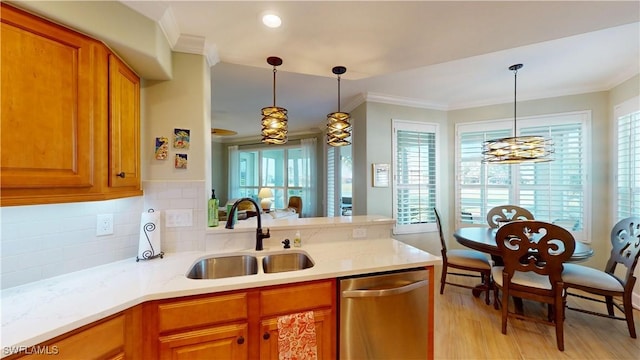 kitchen featuring brown cabinets, dishwasher, and a sink