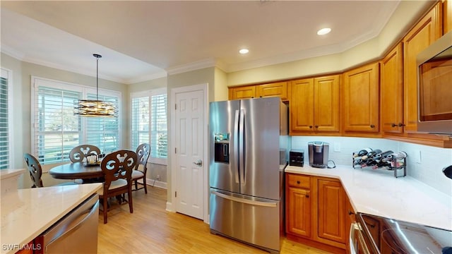 kitchen featuring stainless steel appliances, brown cabinetry, ornamental molding, and light wood-style flooring