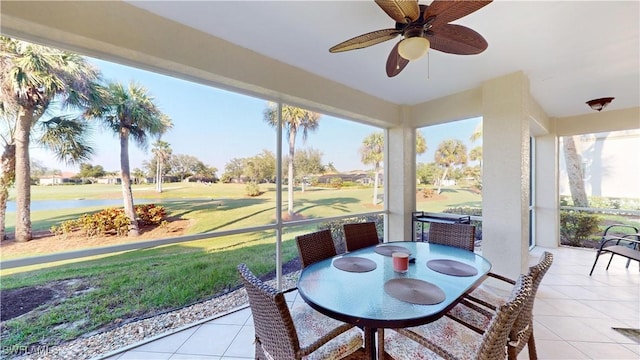 sunroom featuring a water view and ceiling fan