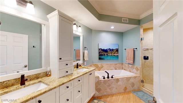 full bathroom with a bath, crown molding, a sink, and a shower stall