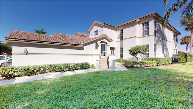 mediterranean / spanish-style house with a tiled roof, a front lawn, and stucco siding