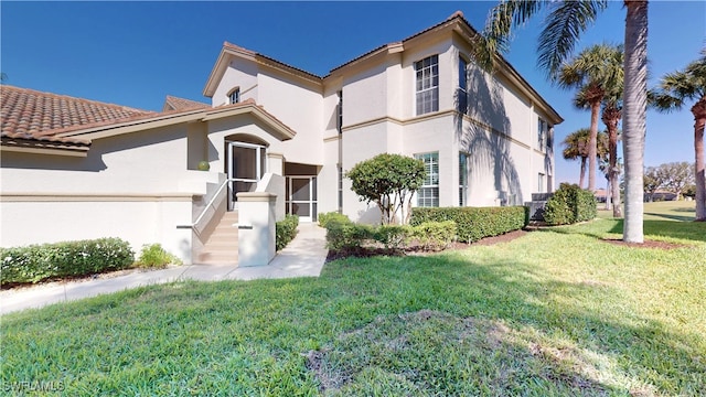 mediterranean / spanish-style house with stucco siding and a front yard