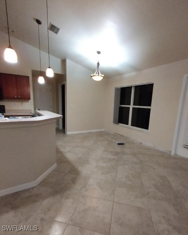 kitchen with decorative light fixtures, vaulted ceiling, visible vents, and baseboards