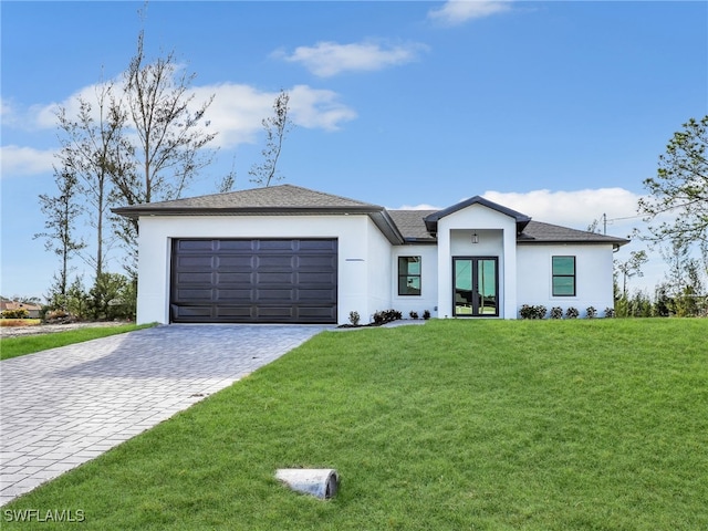 view of front facade featuring stucco siding, a front lawn, decorative driveway, french doors, and an attached garage